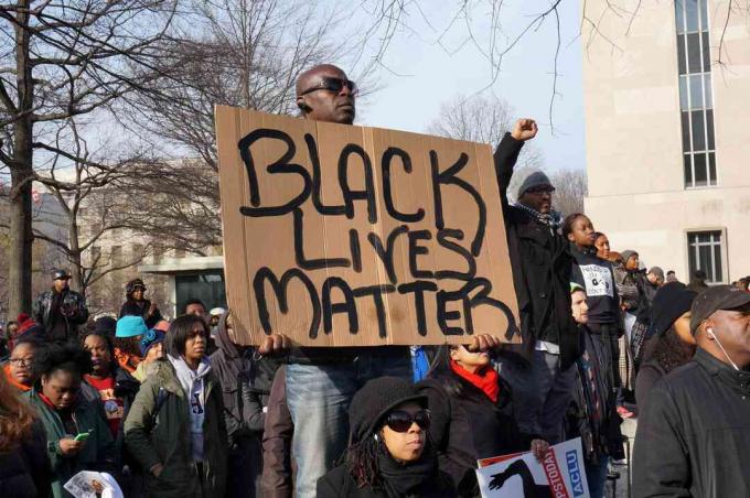 En mand, der protesterer for døden af ​​Michael Brown, Eric Garner og Tamir Rice, viser et Black Lives Matter i Washington DC.