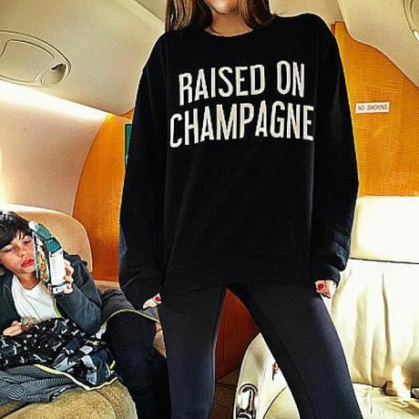 Et foto udgivet til Rich Kids af Instagram viser en pige iført en sweatshirt, der lyder "Opvokset Champagne. "Symbolisk interaktionsteori hjælper os med at forstå, hvordan denne skjorte og fotoet af den skaber mening i samfundet.