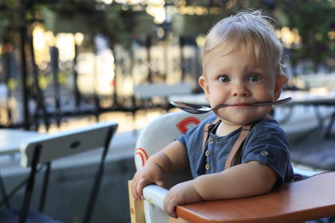 Lille dreng sidder på en café