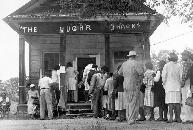 Afroamerikanske vælgere, der er i stand til at stemme for første gang i landdistrikterne i Wilcox County, Alabama, stiller op foran et valgsted efter vedtagelsen af ​​den føderale stemmeretslov i 1965.