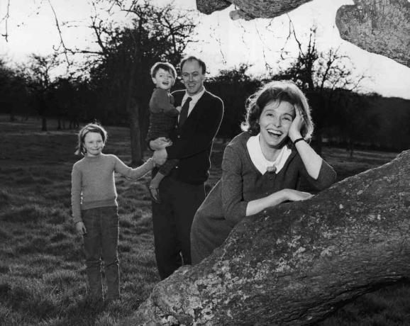 Sort / hvidt foto af Roald Dahl, der holder sine børn; hans kone Patricia Neal læner sig på et træ