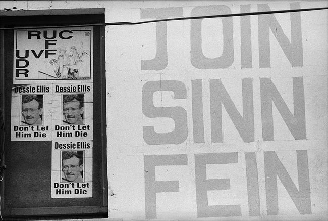 Plakater i Nordirland, der støtter det politiske parti Sinn Fein og sammenligner den nordirske politistyrke med den britiske hær.