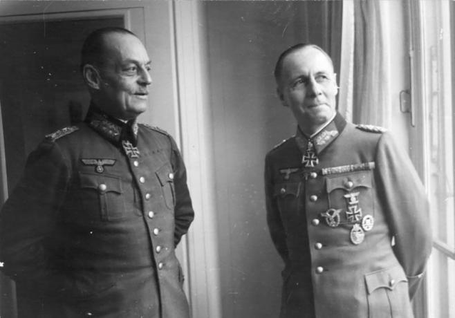 Gerd von Rundstedt og Erwin Rommel i tyske militæruniformer, der står nær et vindue.