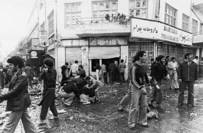 4. november 1978 Folk samles omkring et havari, mens andre plyndrer en butik efter et oprør i Teheran