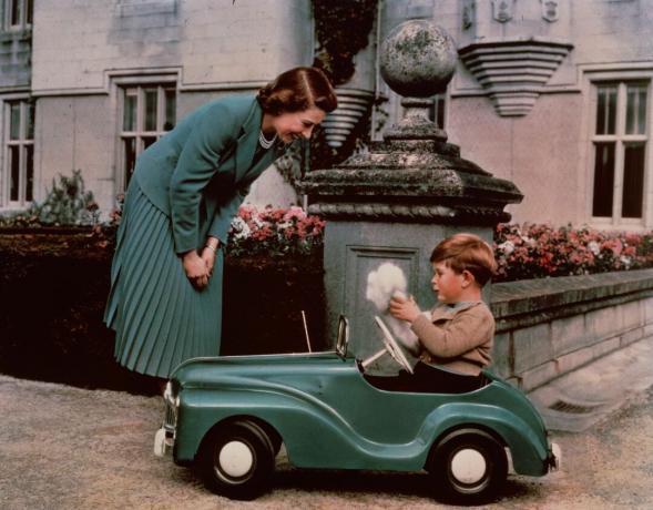 28. september 1952: Prinsesse Elizabeth ser på sin søn prins Charles lege i sin legetøjsbil, mens han var på Balmoral.